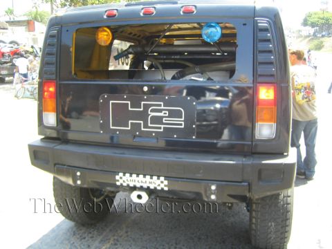 1990 Ford Bronco - Straight rear view of a black Hummer H2 with an H2 logo tailgate plate, dual tail lights and a rear bumper.