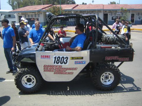 1990 Ford Bronco - Side view of a black and white side-by-side UTV number 1803 with Ranger Performance Race Built decals and a driver seated.