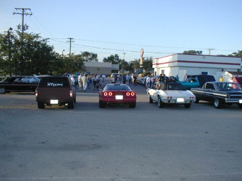 1998 Ford Taurus - Outdoor car gathering with multiple vehicles and attendees under a clear sky.