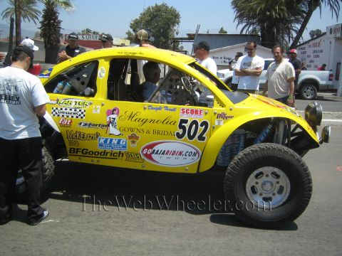 1990 Ford Bronco - Side view of a yellow VW-based Baja Bug race car number 502 with Magnolia Gowns & Bridal and BFGoodrich sponsor graphics.