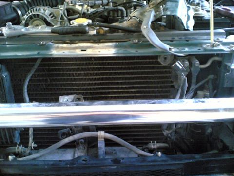 2000 Mitsubishi Montero - Close-up of a vehicle's engine bay, focusing on the radiator and associated plumbing.