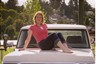 1976 Ford F-150 - A woman poses on the hood of a white pickup truck outdoors.