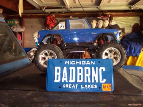 1974 Ford Bronco - A remote-controlled Ford Bronco model is displayed with a custom Michigan license plate in a garage setting.