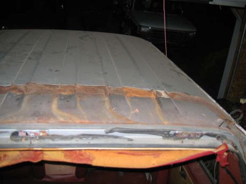 1986 Ford C-350 (Centurion Conversions) - Close-up of a heavily rusted vehicle roof panel, with another vehicle visible in the background.