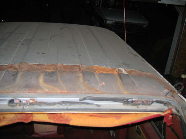 Bare stripped truck cab roof panel with rust along the rear seam and drip rail