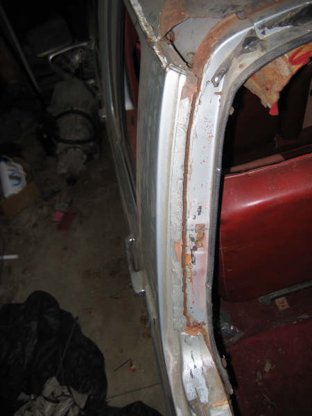 1986 Ford C-350 (Centurion Conversions) - Close-up view of the interior door frame, showing rust and the red upholstery of the seat.