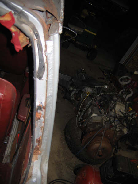 1986 Ford C-350 (Centurion Conversions) - Interior view of a vehicle with visible rust and engine parts, alongside other items in a workshop.