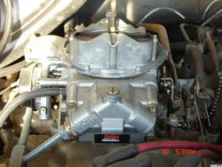 1986 Ford C-350 (Centurion Conversions) - A detailed view of a carburetor, likely from an older vehicle, with a prominent Holley brand sticker.