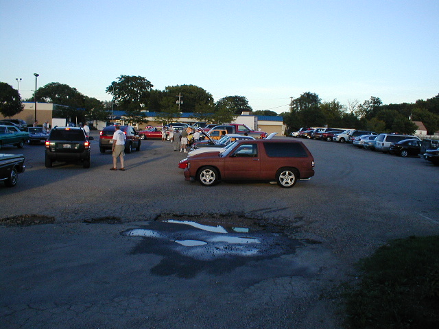 Parking lot scene with multiple cars, including a brown SUV in the foreground