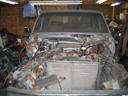 1986 Ford C-350 (Centurion Conversions) - The front end of a truck is shown with its engine and some components removed, revealing the radiator and chassis.