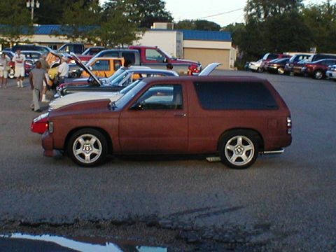 1998 Ford Taurus - A red SUV is parked in a lot with other vehicles visible in the background.