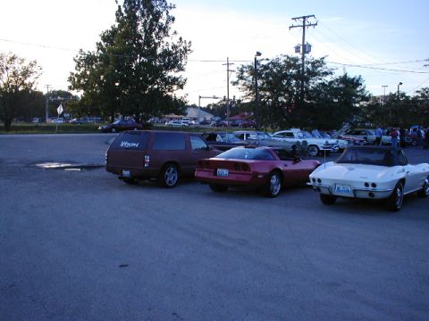 1998 Ford Taurus - A collection of vehicles are parked in an outdoor lot under a hazy sky.