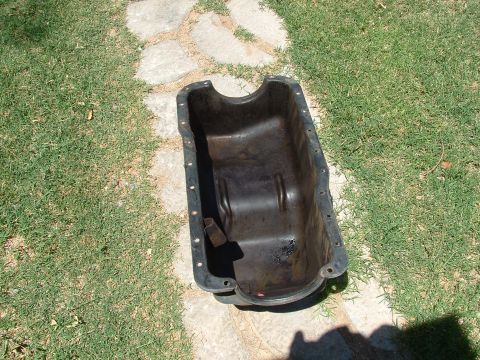 1990 Ford Bronco - This is an oil pan, likely removed from a vehicle for repair or replacement.