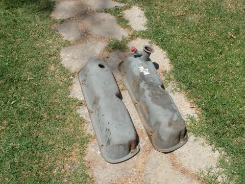 1990 Ford Bronco - Pair of engine valve covers resting on a stone pathway outdoors.