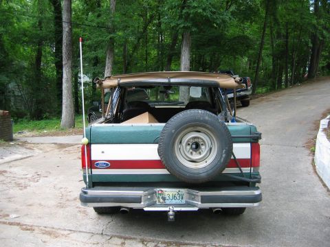 1990 Ford Bronco - This Ford Bronco is parked in a driveway with trees in the background. A second vehicle is parked further up the driveway.