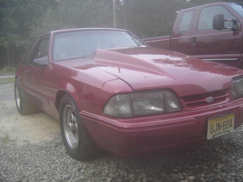 Red coupe with aftermarket hood and New Jersey plate