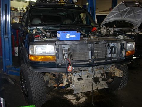 1993 Ford Bronco - This Ford F-Series truck is in a garage with its hood up and front end disassembled for repairs.