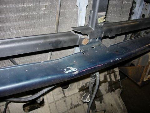 1993 Ford Bronco - Close-up of a damaged vehicle bumper support and radiator, indicating repair or replacement needs.