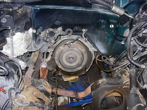 1993 Ford Bronco - Close-up view of the engine bay, focusing on the transmission bell housing and surrounding components.