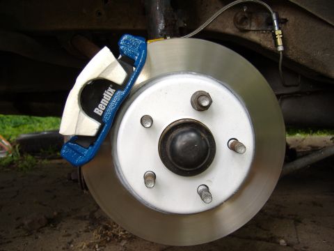 1998 Ford Taurus - A close-up view of a vehicle's brake system, a Bendix caliper and a new rotor.