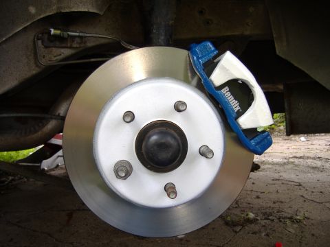 1998 Ford Taurus - Close-up view of a freshly painted Bendix brake caliper and rotor assembly.