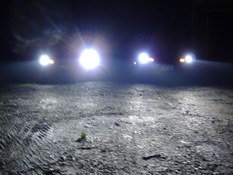 1998 Ford Taurus - The bright headlights of oncoming vehicles illuminate the dark, wet road surface.