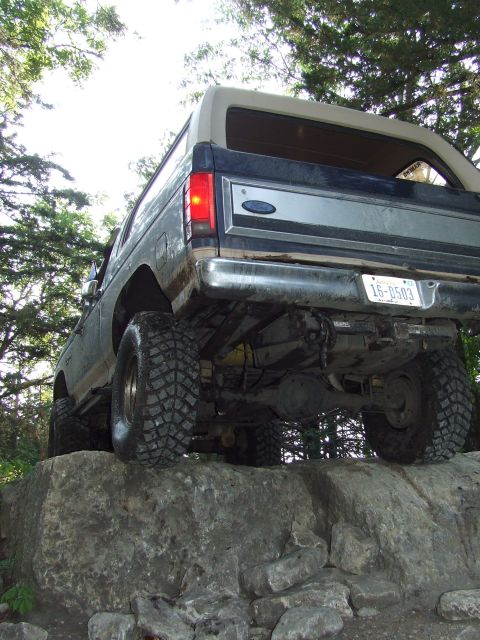 1986 Ford Bronco - Ford Bronco navigating a rocky trail, showing its undercarriage and rear end.