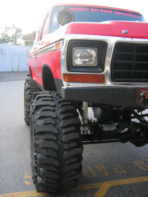 1979 Ford Bronco - This lifted red Ford Bronco features aggressive off-road tires and a distinctive grille.