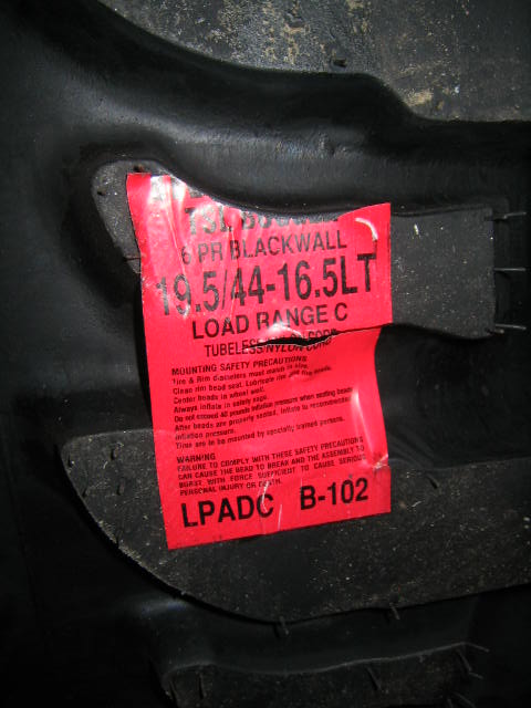 1979 Ford Bronco - A red label on a tire provides mounting safety precautions and tire specifications.
