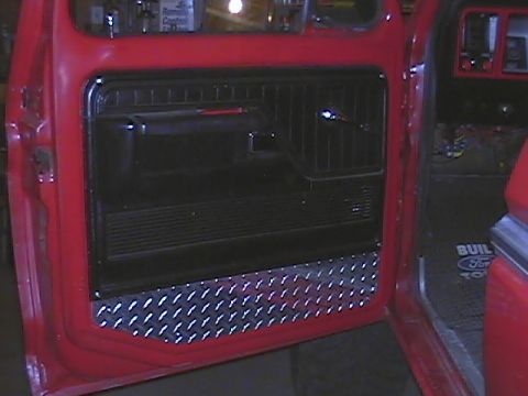 1979 Ford Bronco - Close-up of a vehicle's interior door panel and floor mat, custom diamond plate trim.