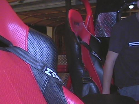 1979 Ford Bronco - Interior view of custom racing seats with prominent branding on the seatbelts.