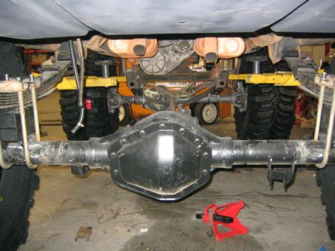 1979 Ford Bronco - Undercarriage view of a vehicle's rear axle and suspension system, supported by jack stands.