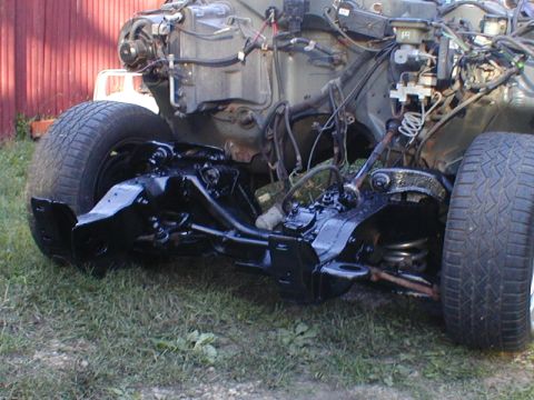 1998 Ford Taurus - The front suspension and engine bay of a vehicle are shown, with the tires still attached.