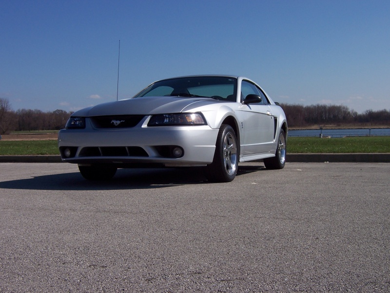 Silver Ford Mustang coupe parked on asphalt, front 3/4 view