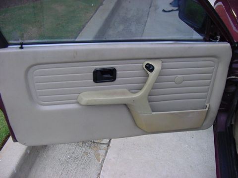 1984 BMW 3 Series - Close-up of a car's interior door panel, showing the armrest and handle.