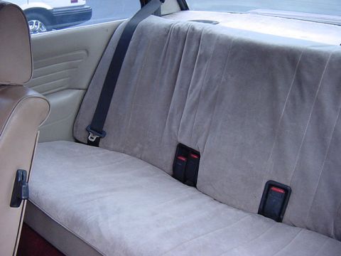 1984 BMW 3 Series - Interior view of a car's rear seat, with a portion of another vehicle visible through the window.