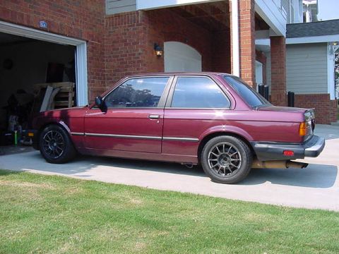 1984 BMW 3 Series - Maroon 1984 BMW 3 Series coupe with aftermarket wheels parked outside a garage.