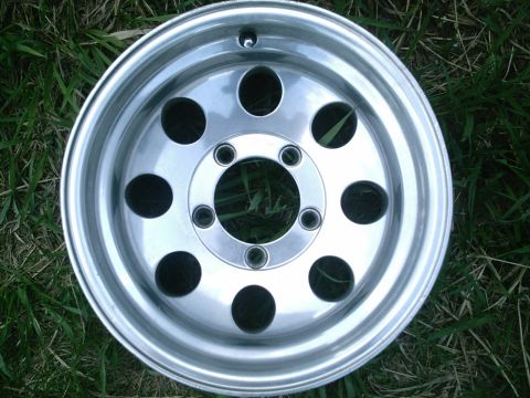 2001 Dodge 2500 - A single aluminum wheel with a five-lug bolt pattern is shown against a grassy background.