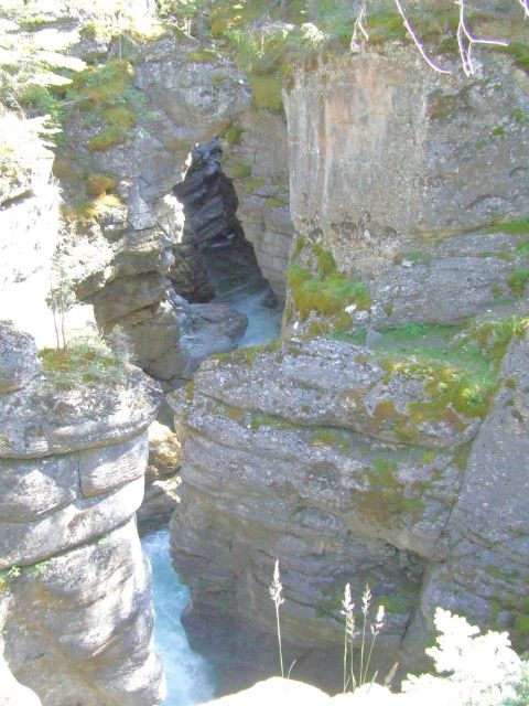 1988 Ford Bronco - A river carves through a rocky canyon under a bright sky.