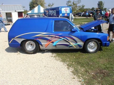 1998 Ford Taurus - This customized blue panel van features unique graphics and aftermarket wheels, with its hood open.