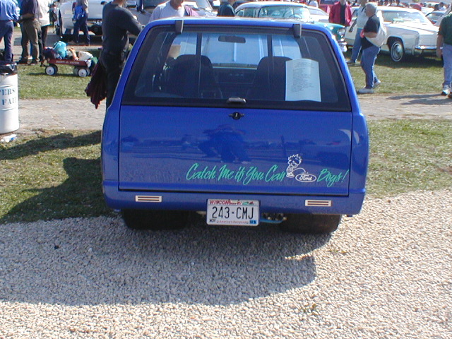 Blue pickup truck with "Catch Me If You Can" sticker and "Ford" logo on tailgate, license plate 243-CMJ