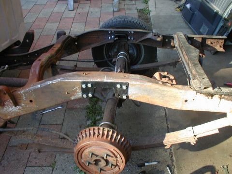 1998 Ford Taurus - The rear chassis frame of a truck is shown, including the leaf springs and a drum brake assembly on the rear axle.