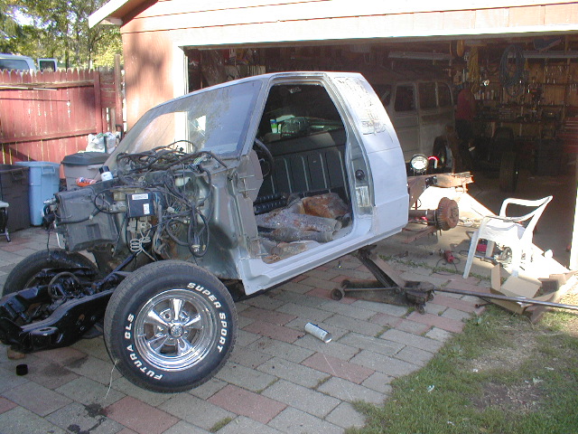 pickup truck body on jack stands, engine bay exposed, interior visible