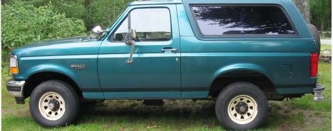 1996 Ford Bronco - This teal Ford Bronco is shown from the side, with a spare tire mounted on the rear.