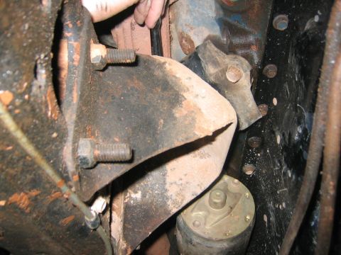1979 Ford Bronco - Close-up view of engine motor mounts, bolts, and a starter motor, likely from a vintage vehicle.