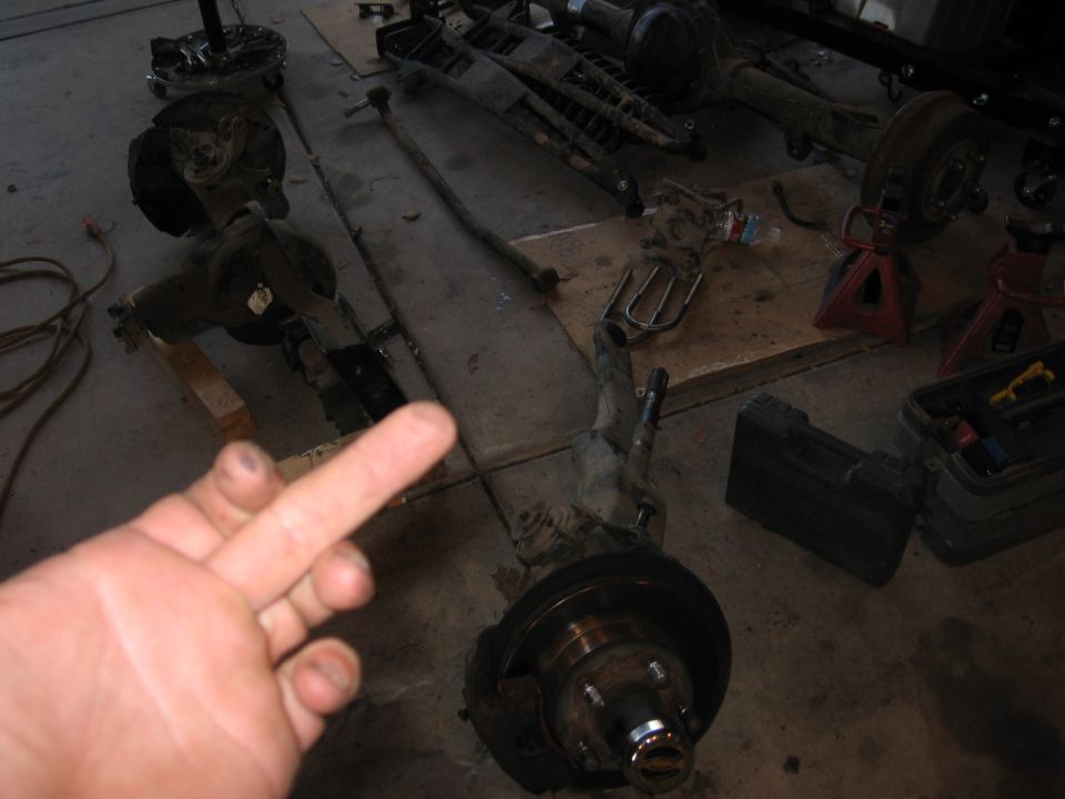Vehicle axle assemblies and suspension parts laid out on a garage floor