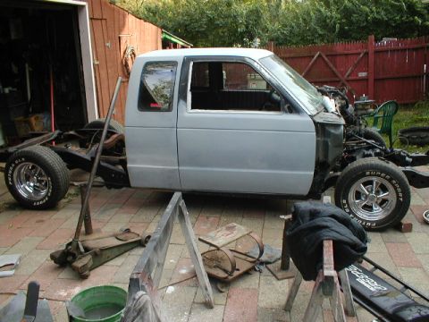 1998 Ford Taurus - This pickup truck is undergoing some work, with its body separated from the chassis and engine components exposed.