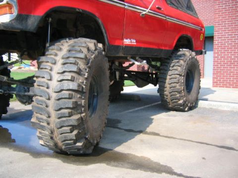 1979 Ford Bronco - This lifted SUV displays a prominent side profile, highlighting its substantial off-road tires and modified suspension system.