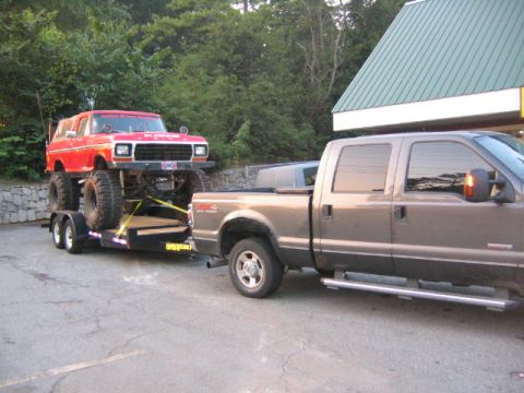 2005 Ford F-250 - Gray Ford F-250 tows a red lifted Ford Bronco on a trailer.