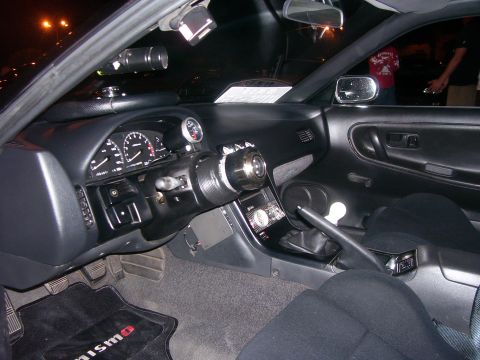 1994 Ford Probe - Interior view of a car with custom modifications, including a Nismo floor mat and additional gauges.